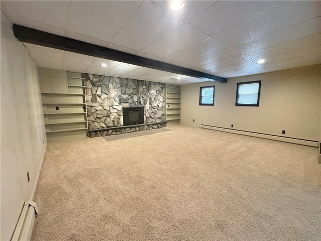 12017 Birch Dr, Corning, NY 14830 - basement featuring a baseboard heating unit, carpet flooring, a fireplace, built in shelves, and a drop ceiling