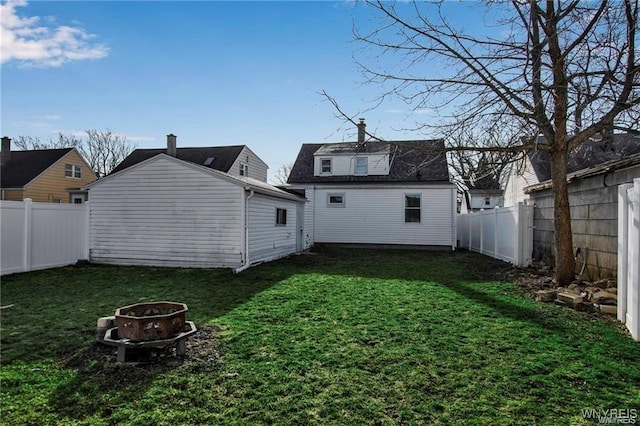 40 Remington Pl, Buffalo, NY 14210 - rear view of property featuring an outdoor fire pit, a fenced backyard, roof with shingles, and an outdoor structure