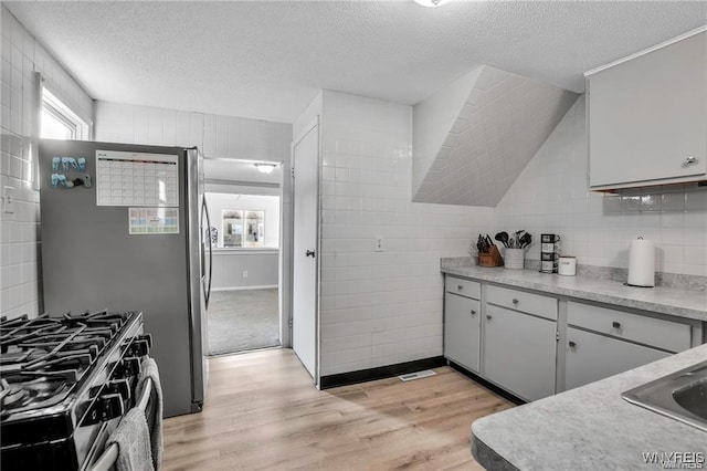 40 Remington Pl, Buffalo, NY 14210 - kitchen featuring stainless steel range with gas cooktop, light wood-type flooring, a textured ceiling, light countertops, and decorative backsplash