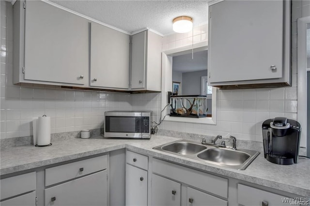 40 Remington Pl, Buffalo, NY 14210 - kitchen with stainless steel microwave, light countertops, a textured ceiling, decorative backsplash, and ornamental molding