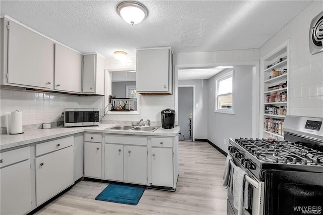 40 Remington Pl, Buffalo, NY 14210 - kitchen featuring appliances with stainless steel finishes, light wood finished floors, a textured ceiling, light countertops, and decorative backsplash