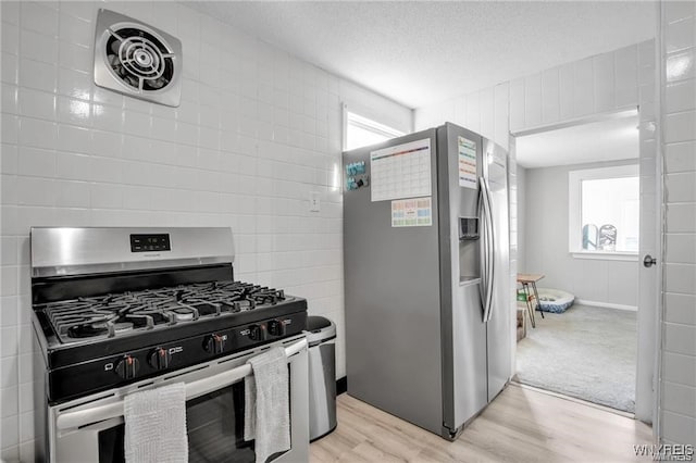 40 Remington Pl, Buffalo, NY 14210 - kitchen featuring appliances with stainless steel finishes, light wood-style floors, healthy amount of natural light, a textured ceiling, and tile walls