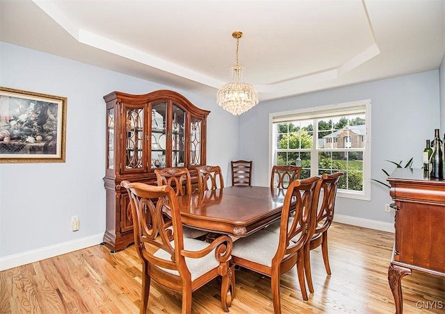 7991 Austrian Pine Cir, Pompey, NY 13104 - dining space with a raised ceiling, a chandelier, and light wood-type flooring