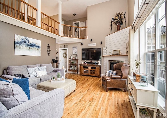 7991 Austrian Pine Cir, Pompey, NY 13104 - living room with wood finished floors, a high ceiling, and a fireplace