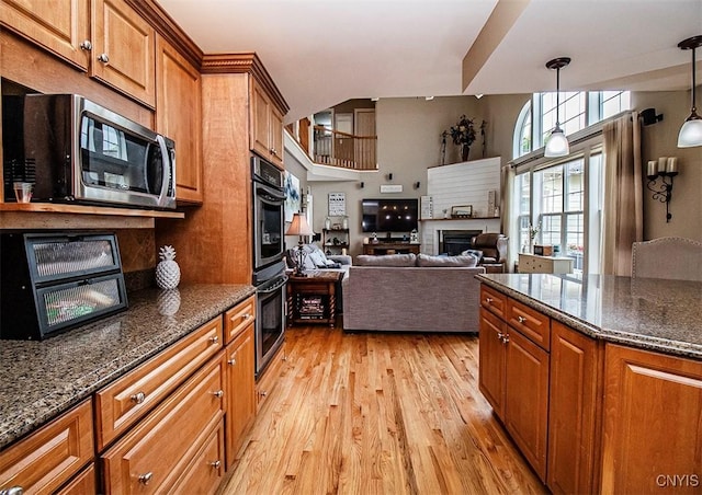 7991 Austrian Pine Cir, Pompey, NY 13104 - kitchen featuring stainless steel appliances, light wood-style flooring, brown cabinetry, and hanging light fixtures