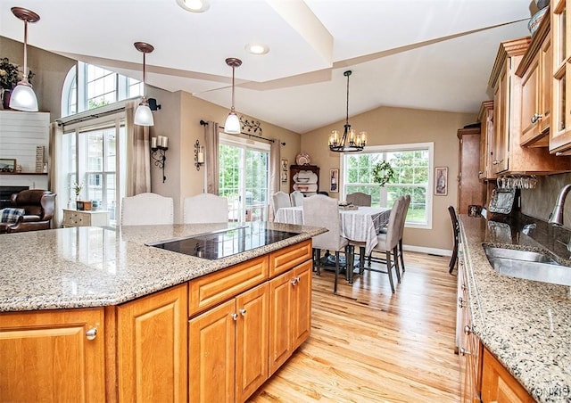 7991 Austrian Pine Cir, Pompey, NY 13104 - kitchen with black electric cooktop, light wood-style flooring, a chandelier, vaulted ceiling, and light stone counters