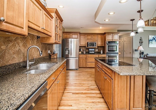 7991 Austrian Pine Cir, Pompey, NY 13104 - kitchen featuring stainless steel appliances, light wood-type flooring, brown cabinetry, pendant lighting, and a center island