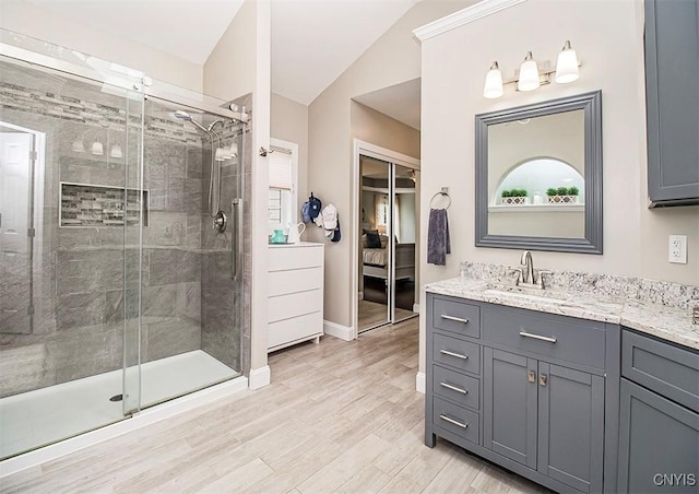 7991 Austrian Pine Cir, Pompey, NY 13104 - ensuite bathroom with vaulted ceiling, vanity, a stall shower, and wood finished floors