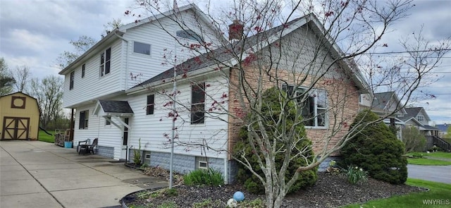 239 Bullis Rd, West Seneca, NY 14224 - view of side of property featuring a chimney and a storage unit