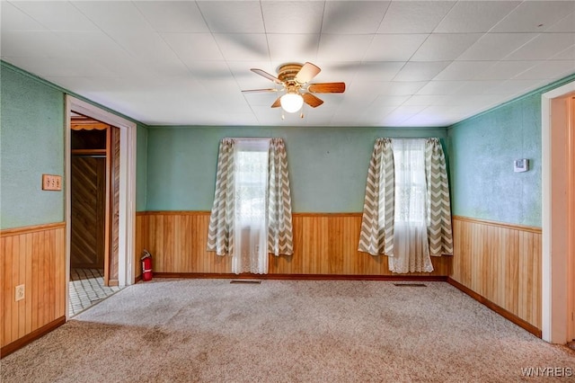 5910 Edgewood Dr, Niagara, NY 14304 - spare room with ceiling fan, a wainscoted wall, wood walls, and carpet
