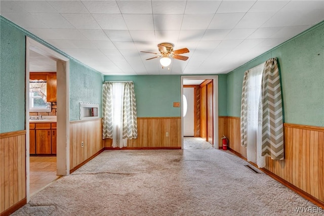 5910 Edgewood Dr, Niagara, NY 14304 - carpeted empty room with wainscoting, wood walls, and ceiling fan
