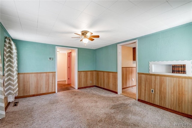 5910 Edgewood Dr, Niagara, NY 14304 - carpeted spare room with wainscoting, a ceiling fan, and wood walls