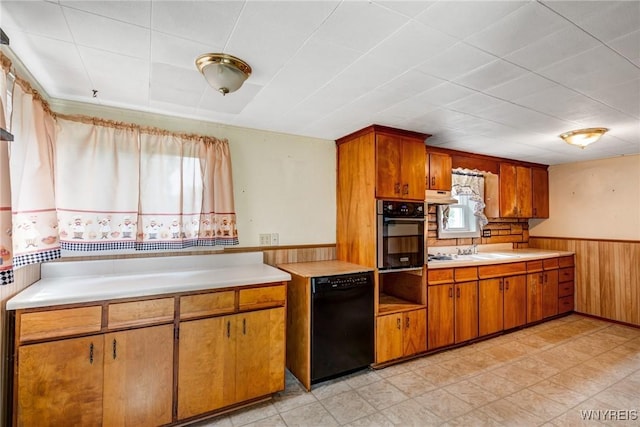 5910 Edgewood Dr, Niagara, NY 14304 - kitchen featuring black dishwasher, stainless steel oven, light countertops, wainscoting, and under cabinet range hood