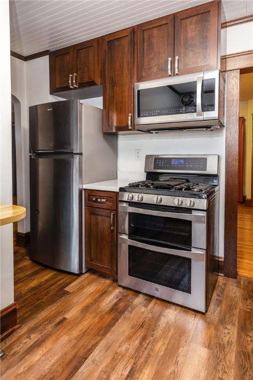 1995 Grand Central Ave, Horseheads, NY 14845 - kitchen featuring stainless steel appliances, light countertops, wood finished floors, arched walkways, and dark brown cabinets
