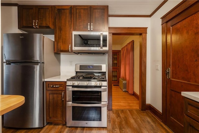 1995 Grand Central Ave, Horseheads, NY 14845 - kitchen with appliances with stainless steel finishes, radiator heating unit, light countertops, wood finished floors, and crown molding