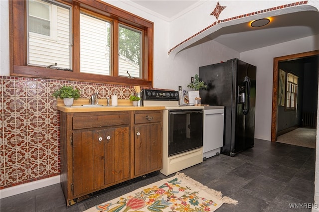 2912 Eggert Rd, Tonawanda, NY 14150 - kitchen with white electric stove, light countertops, black fridge, and brown cabinetry