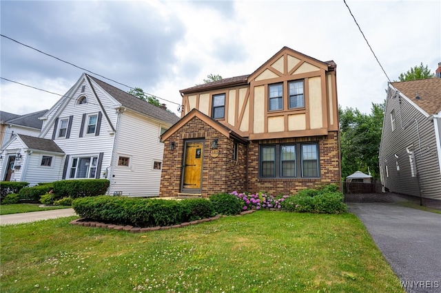 2912 Eggert Rd, Tonawanda, NY 14150 - tudor house featuring stucco siding, brick siding, and a front lawn