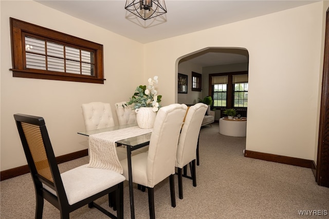 2912 Eggert Rd, Tonawanda, NY 14150 - dining space with arched walkways, carpet floors, and a chandelier