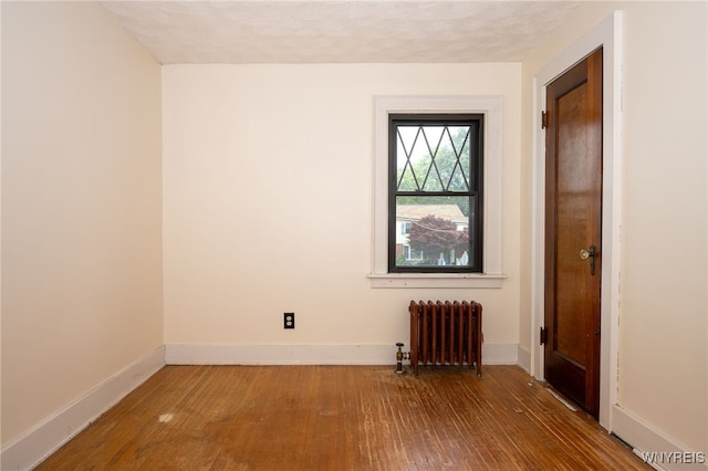 2912 Eggert Rd, Tonawanda, NY 14150 - unfurnished room featuring radiator and hardwood / wood-style floors