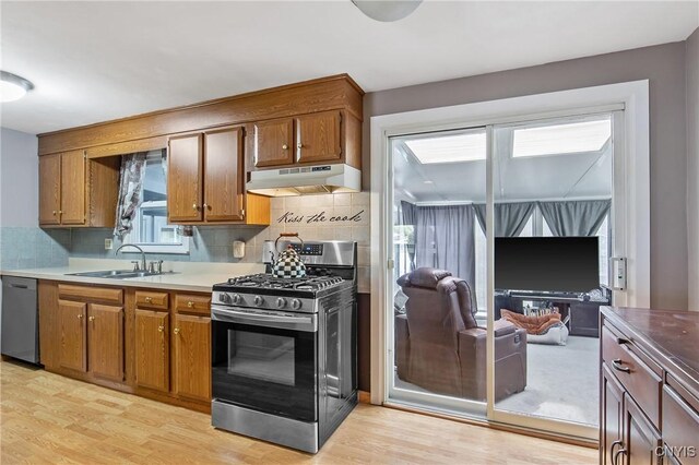 511 Drexler St, Salina, NY 13088 - kitchen with stainless steel appliances, under cabinet range hood, light wood-style flooring, and tasteful backsplash