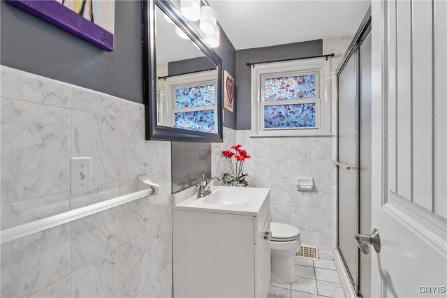 511 Drexler St, Salina, NY 13088 - bathroom featuring a stall shower, tile walls, vanity, tile patterned floors, and wainscoting