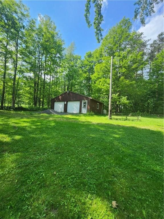 142 John Smith Rd, Pharsalia, NY 13844 - view of green lawn featuring a detached garage and an outbuilding