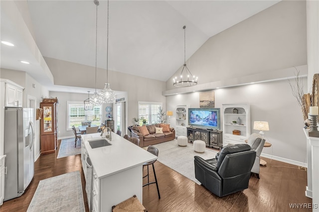 9443 Heritage Path Unit B, Clarence, NY 14032 - kitchen featuring stainless steel appliances, a chandelier, open floor plan, a kitchen island with sink, and high vaulted ceiling