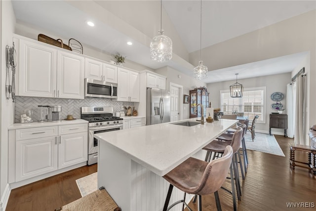9443 Heritage Path Unit B, Clarence, NY 14032 - kitchen with appliances with stainless steel finishes, lofted ceiling, tasteful backsplash, a kitchen island with sink, and white cabinets