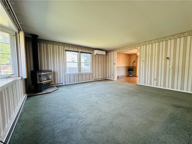 55 Wegman St, Sennett, NY 13021 - unfurnished living room featuring wallpapered walls, a wall mounted AC, baseboard heating, a wood stove, and carpet flooring