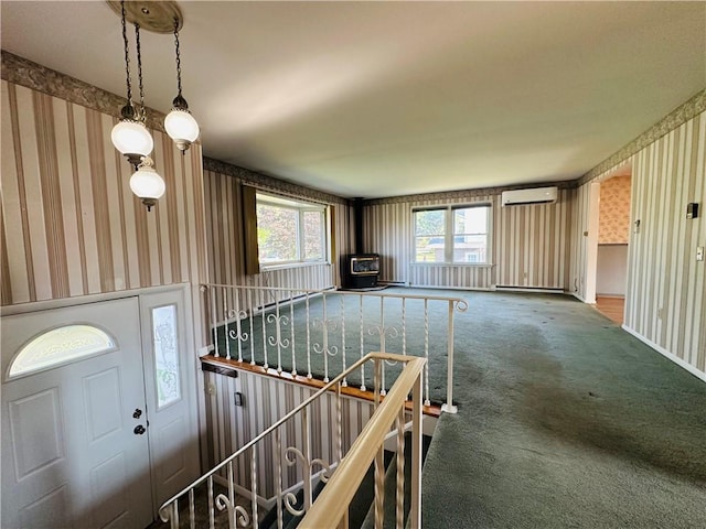 55 Wegman St, Sennett, NY 13021 - carpeted foyer entrance featuring wallpapered walls, a wall mounted AC, and a wood stove