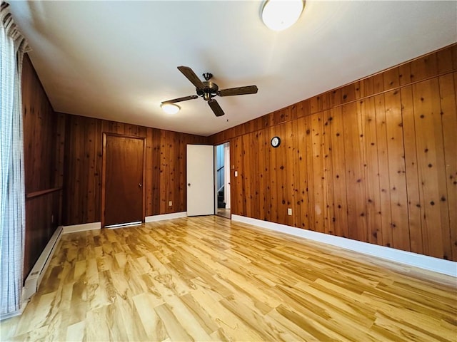 55 Wegman St, Sennett, NY 13021 - unfurnished bedroom featuring light wood-type flooring, wooden walls, a baseboard radiator, and ceiling fan