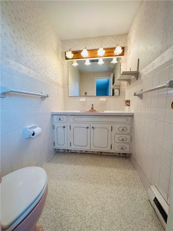 55 Wegman St, Sennett, NY 13021 - half bath with tile walls, wallpapered walls, a baseboard heating unit, vanity, and a wainscoted wall
