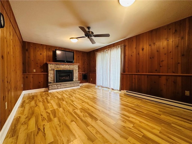 55 Wegman St, Sennett, NY 13021 - unfurnished living room with ceiling fan, wood finished floors, wood walls, a fireplace, and baseboard heating
