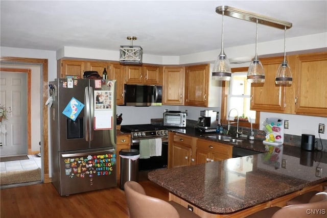 115 Meaney Cir, Scriba, NY 13126 - kitchen with appliances with stainless steel finishes, a peninsula, decorative light fixtures, brown cabinetry, and a breakfast bar