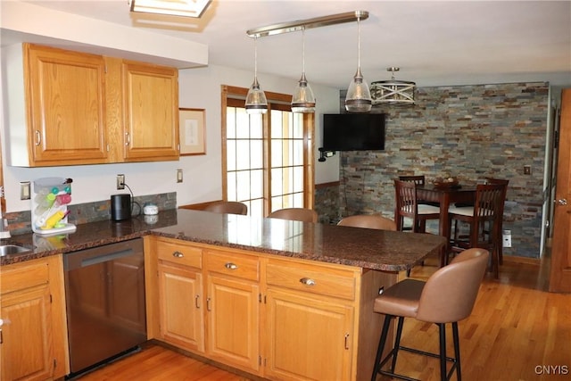 115 Meaney Cir, Scriba, NY 13126 - kitchen featuring dishwasher, a peninsula, light wood-type flooring, dark stone countertops, and a breakfast bar area