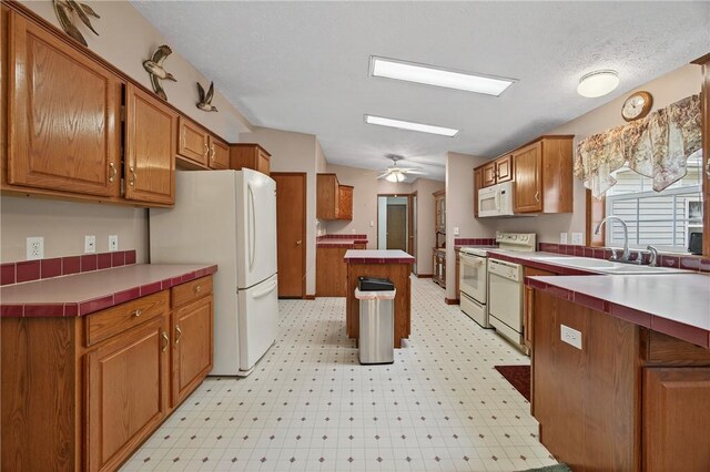 7219 Apple St, Bath, NY 14810 - kitchen with white appliances, light floors, brown cabinets, and a ceiling fan
