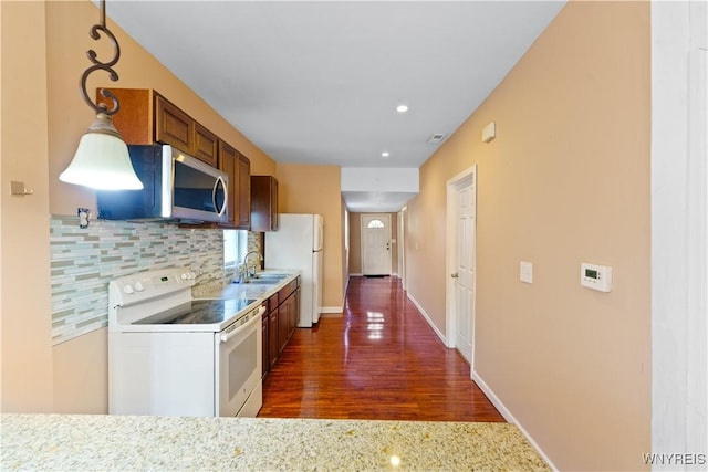2275 Broadway St, Cheektowaga, NY 14212 - kitchen featuring white appliances, dark wood finished floors, decorative backsplash, brown cabinets, and recessed lighting