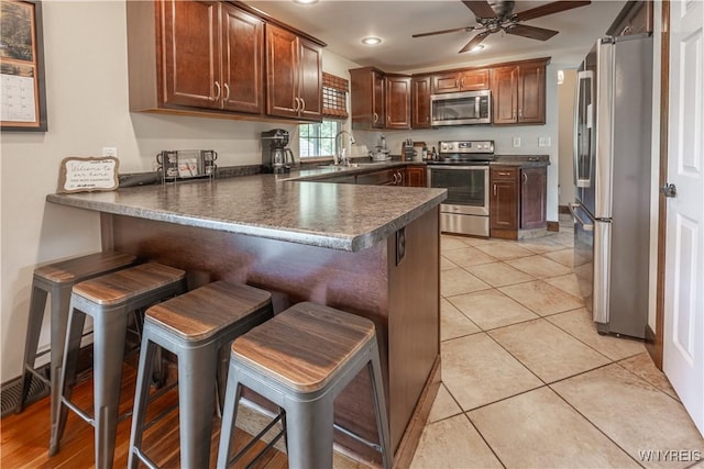 283 Erin Rd, Ridgeway, NY 14103 - kitchen featuring stainless steel appliances, a peninsula, dark countertops, a ceiling fan, and recessed lighting