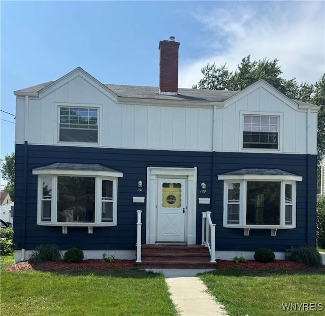 129 Brookside Dr, West Seneca, NY 14220 - view of front of home featuring a chimney, a front yard, and board and batten siding