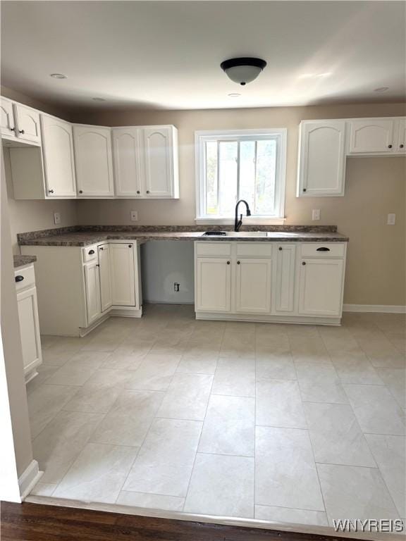 129 Brookside Dr, West Seneca, NY 14220 - kitchen with white cabinetry, light tile patterned flooring, and dark countertops