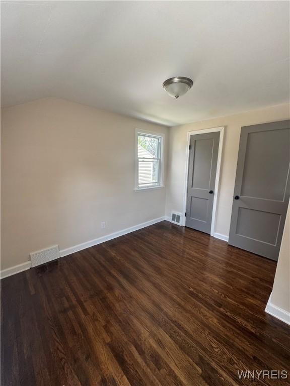 129 Brookside Dr, West Seneca, NY 14220 - unfurnished bedroom with dark wood finished floors and vaulted ceiling