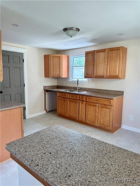 129 Brookside Dr, West Seneca, NY 14220 - kitchen with brown cabinets, light tile patterned flooring, and stone countertops
