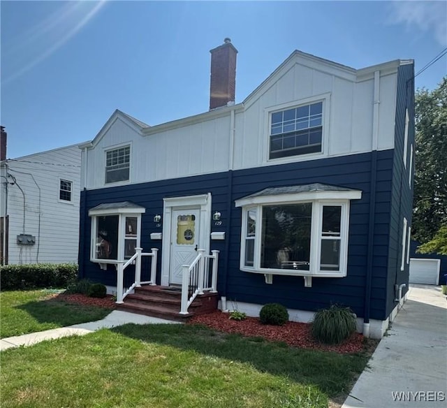 129 Brookside Dr, West Seneca, NY 14220 - view of front of house featuring a front yard, a chimney, and board and batten siding