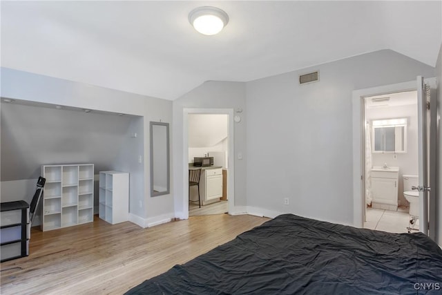 101 Comstock Ave, Syracuse, NY 13210 - bedroom with lofted ceiling, ensuite bathroom, and light wood-style floors