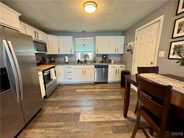 119 Marnie St, Deerfield, NY 13502 - kitchen with stainless steel appliances, white cabinetry, stone countertops, dark wood finished floors, and a textured ceiling