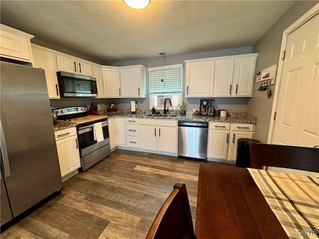 119 Marnie St, Deerfield, NY 13502 - kitchen with appliances with stainless steel finishes, white cabinetry, dark wood-type flooring, dark stone countertops, and a textured ceiling