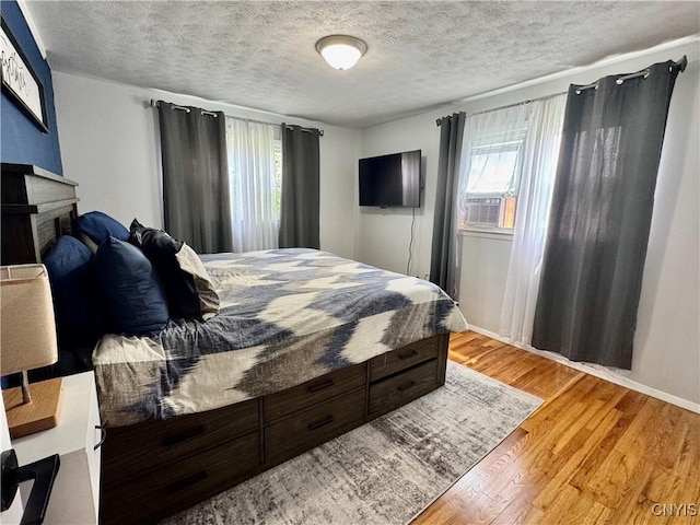 119 Marnie St, Deerfield, NY 13502 - bedroom with cooling unit, a textured ceiling, wood finished floors, and a fireplace