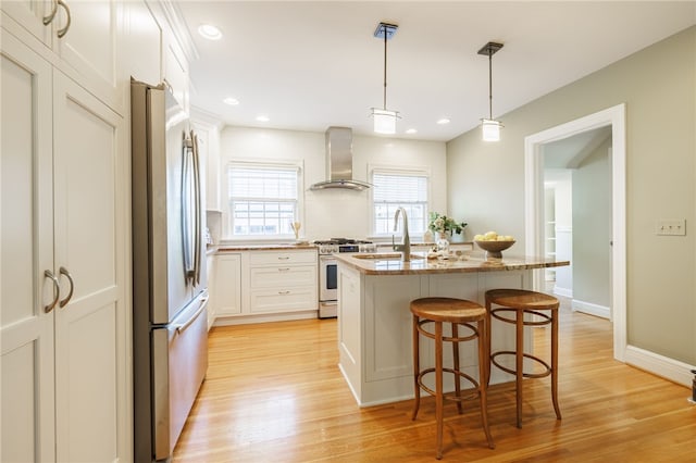 441 Claybourne Rd, Brighton, NY 14618 - kitchen with wall chimney exhaust hood, stainless steel appliances, a kitchen bar, light wood-type flooring, and recessed lighting