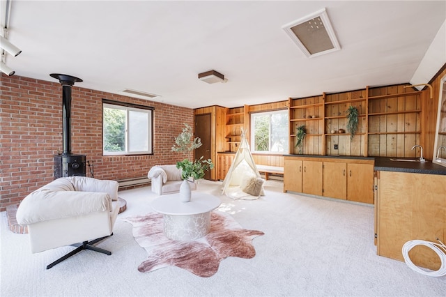 441 Claybourne Rd, Brighton, NY 14618 - sitting room with healthy amount of natural light, a wood stove, brick wall, light carpet, and baseboard heating