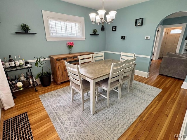 153 Milnor Ave, Syracuse, NY 13224 - dining space with arched walkways, light wood-style floors, and a chandelier